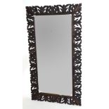 Early 20th century bevelled wall mirror set in a foliate carved frame, inscription to the reverse,