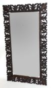 Early 20th century bevelled wall mirror set in a foliate carved frame, inscription to the reverse,