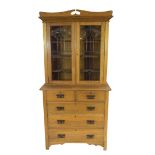 Late 19th century light oak two-piece cabinet, the top section with double glazed doors with Art