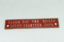 Small cast brass plaque marked "Clean out the boiler every 14 days"