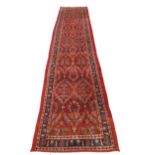Large red ground Persian Kashan Runner, with all-over floral pattern 397cm x 93cm approximately No