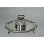 Late Victorian silver ink stand of shaped rectangular form resting on four splayed feet with