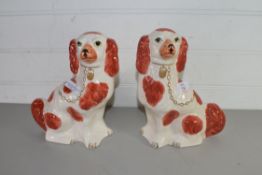 PAIR OF STAFFORDSHIRE STYLE SPANIELS DECORATED IN LIVER AND WHITE
