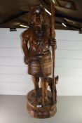 20TH CENTURY CARVED HARDWOOD FIGURE WITH DOG RAISED ON A PLINTH BASE, 90CM HIGH