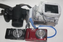 Lumix DMC -F27 together with a Lumix DMW-MCT 220, a Hitachi camcorder, a Fujifilim F10 and a Canon