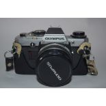 Olympus OM-10 film camera with accessories including strap, flash and Makinon MC35-100mm lens and