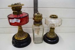 THREE OIL LAMP BASES TO INCLUDE ONE WITH CRANBERRY GLASS FONT