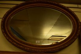 LARGE EARLY 20TH CENTURY OVAL BEVELLED WALL MIRROR IN GILT FINISH FRAME, 89CM WIDE