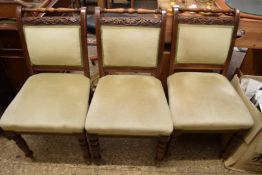 SET OF THREE LATE VICTORIAN DINING CHAIRS, THE FRAMED CARVED WITH OAK LEAF AND ACORN DETAIL