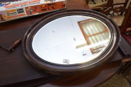 EARLY 20TH CENTURY OVAL BEVELLED WALL MIRROR IN DARK WOOD FRAME, 71CM WIDE