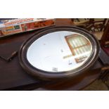 EARLY 20TH CENTURY OVAL BEVELLED WALL MIRROR IN DARK WOOD FRAME, 71CM WIDE