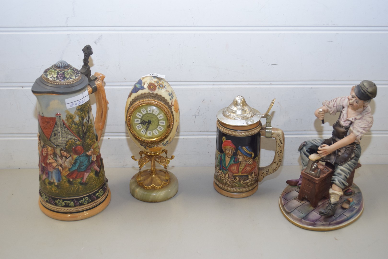 LARGE GERMAN POTTERY BEER STEIN DECORATED WITH FIGURES TOGETHER WITH A FURTHER SMALLER EXAMPLE, A