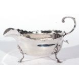 Edward VII silver sauce boat in the Georgian style fitted with looped handle and raised on three