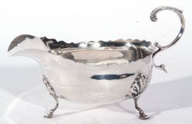 Edward VII silver sauce boat in the Georgian style fitted with looped handle and raised on three