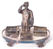 Unusual Victorian silver plated desk stand mounted with a figure of a shoeshine boy set on an oval