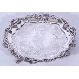 George IV silver waiter tray with floral border and engraved centre set on three swept legs with paw