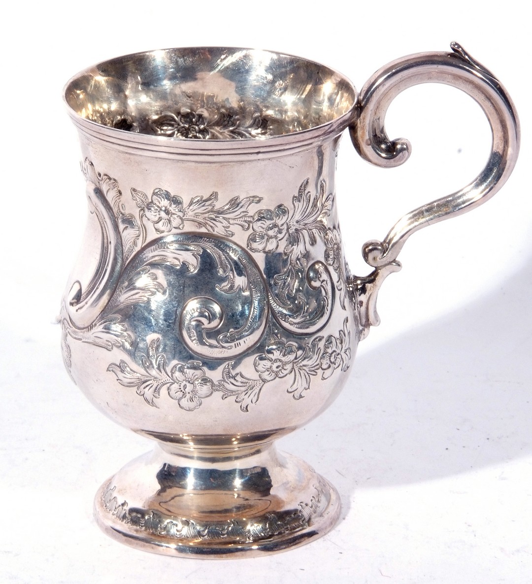 A small Victorian silver tankard with scrolled handle, baluster body decorated with sinuous floral