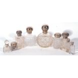 Collection of nine various cut clear glass and silver topped dressing table jars and bottles, late
