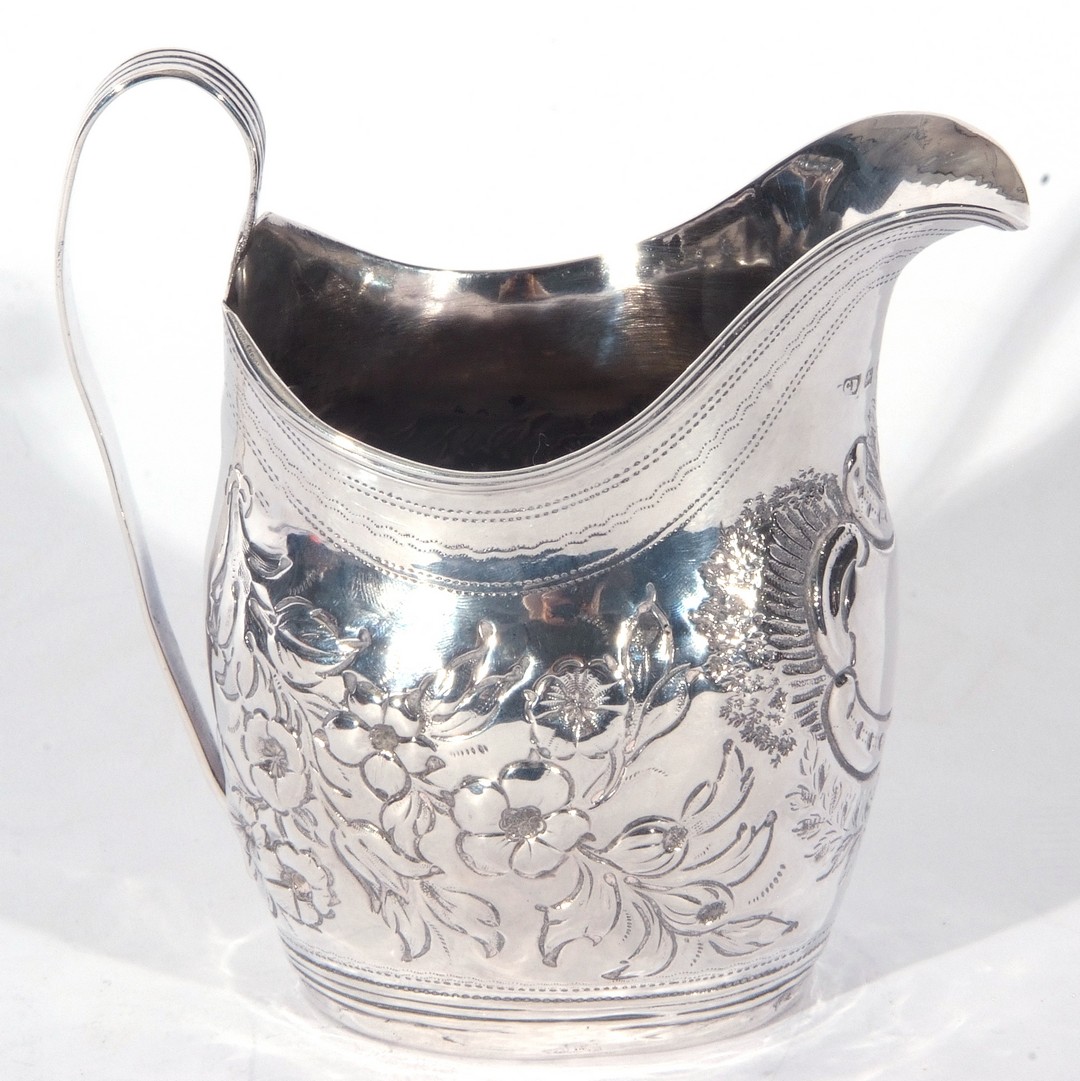 George III silver helmet formed cream jug with looped handle, the body with later floral