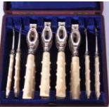 An unusual cased set of four silver plated and ivory handled lobster or crab crackers and