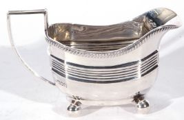 Edward VII silver cream jug, the body with looped handle and ribbed decoration raised on four ball