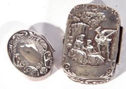 Two white metal pill boxes, one of hinged rectangular form, the lid decorated with figures in a