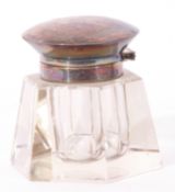 George V clear glass inkwell of hexagonal form fitted with a hinged silver lid and collar,