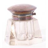 George V clear glass inkwell of hexagonal form fitted with a hinged silver lid and collar,