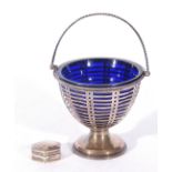 George V silver sugar basket with blue glass liner and with looped handle and pierced body raised on