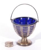 George V silver sugar basket with blue glass liner and with looped handle and pierced body raised on