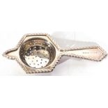 George V silver tea strainer of hexagonal angular form with a lug support, applied with gadrooned