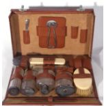 George V brown leather vanity case containing a selection of silver topped clear glass jars and