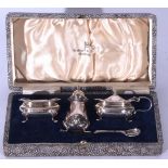 George VI cased silver condiment set comprising a lidded four-footed pepper, a mustard with hinged