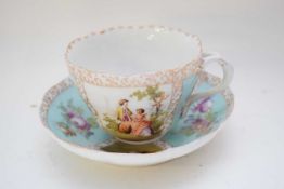 Continental porcelain cup and saucer decorated in Meissen style with panels of figures