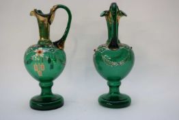 Pair of 19th century green glass ewers with gilt highlights and a design of flowers, 20cm high (2)