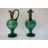 Pair of 19th century green glass ewers with gilt highlights and a design of flowers, 20cm high (2)