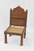 Indian hardwood chair with heavily carved back and a string seat