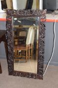 Early 20th century bevelled wall mirror set in a foliate carved frame, inscription to the reverse,