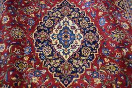 Large Kashan wool floor rug decorated with a large central red and blue panel surrounded by a floral