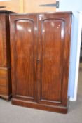 Victorian mahogany linen press cabinet with two large panelled doors opening to an interior with