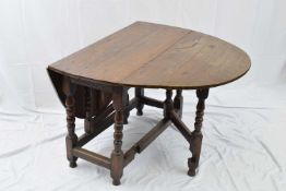 Small oak drop leaf dining table in the 18th century style, the oval top supported on turned