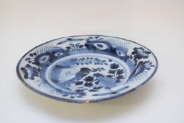 18th century Delft dish with blue and white design of a peacock amongst foliage, 21cm diam