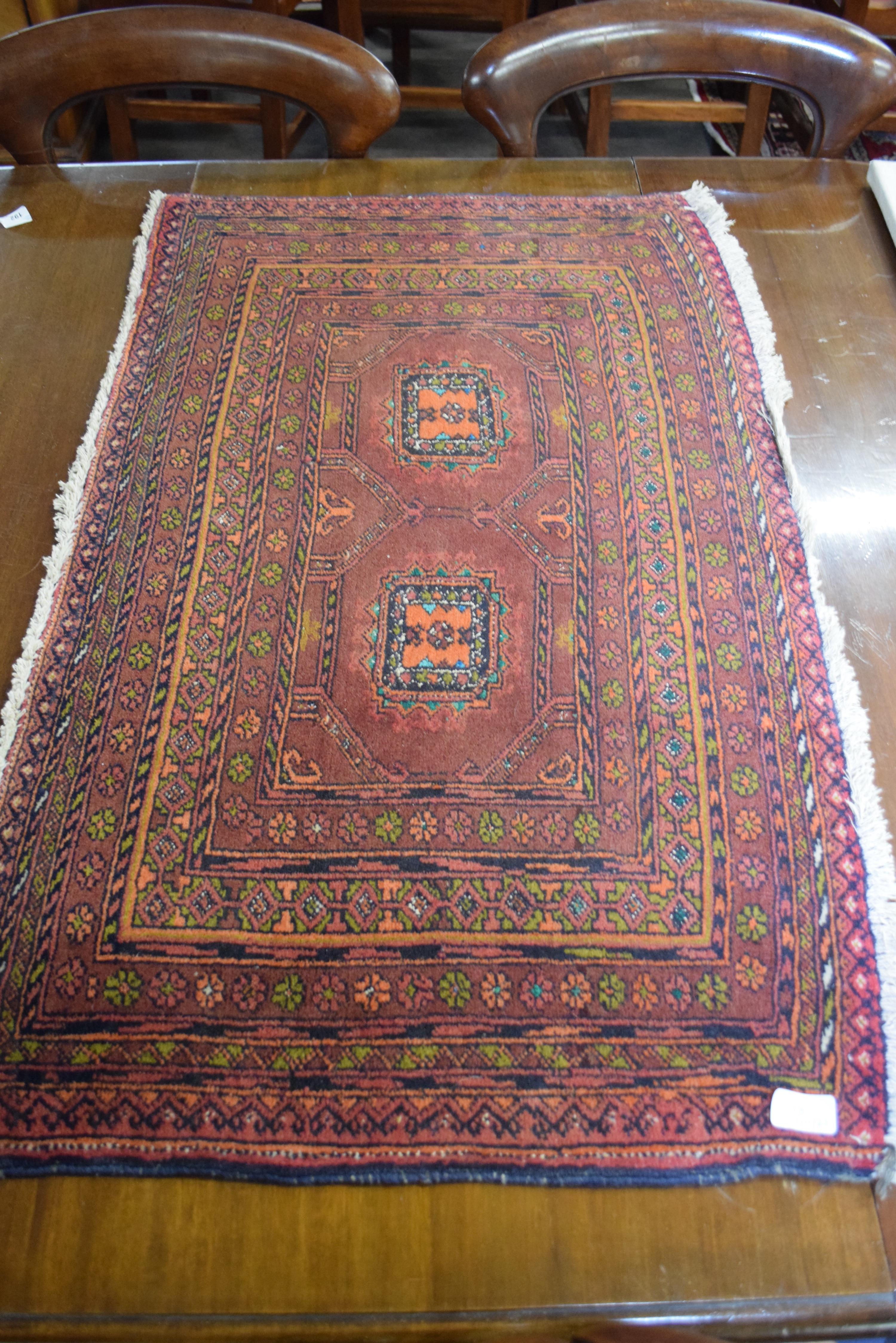 Small Middle Eastern wool carpet or prayer mat decorated with central lozenge on a principally red