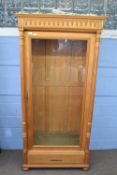 Continental light oak bookcase or display cabinet, moulded cornice over a single glazed door,