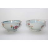 Two Qianlong period bowls with blue and white enamelled designs, mainly of flowers, some in