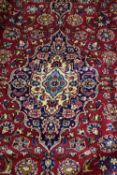 Large wool Kashan carpet decorated with central medallion on a blue and red background, 355 x 250cm