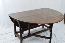 18th century style oval oak drop leaf dining table raised on ring turned legs with heavy stretcher