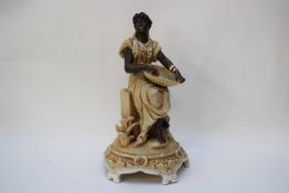 19th century Continental bisque porcelain figure of an African woman with pannier seated on rock