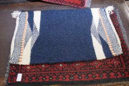Small Bokhara type wool prayer mat decorated with two lozenges on a red background, together with
