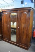 Victorian mahogany wardrobe with triple doors, central mirror and a fitted interior with drawers,